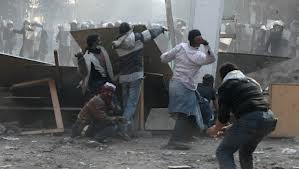 Street fighters in Cairo use plywood sheets as part of a barricade, Jan 25, 2013.