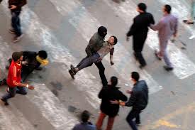 Masked militant rescues injured protester in Cairo, Jan 25, 2013.