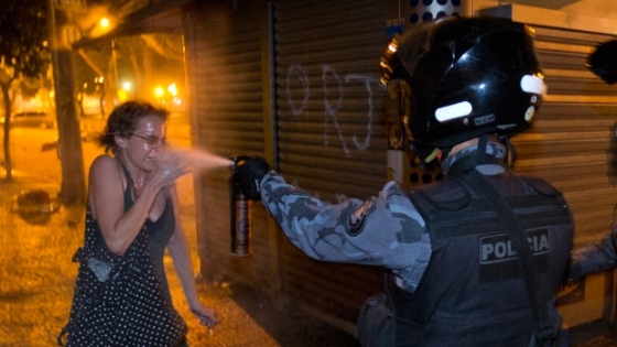 Riot cop pepper sprays a woman during large protests in Brazil, June 2013.