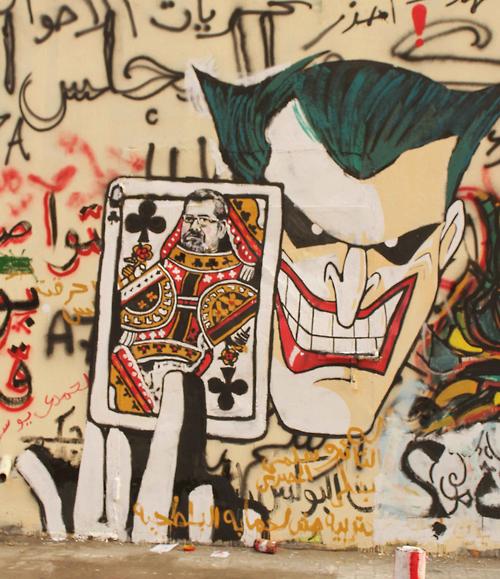 Graffiti in Egypt showing Morsi as the Queen of Clubs in the hands of the Joker.